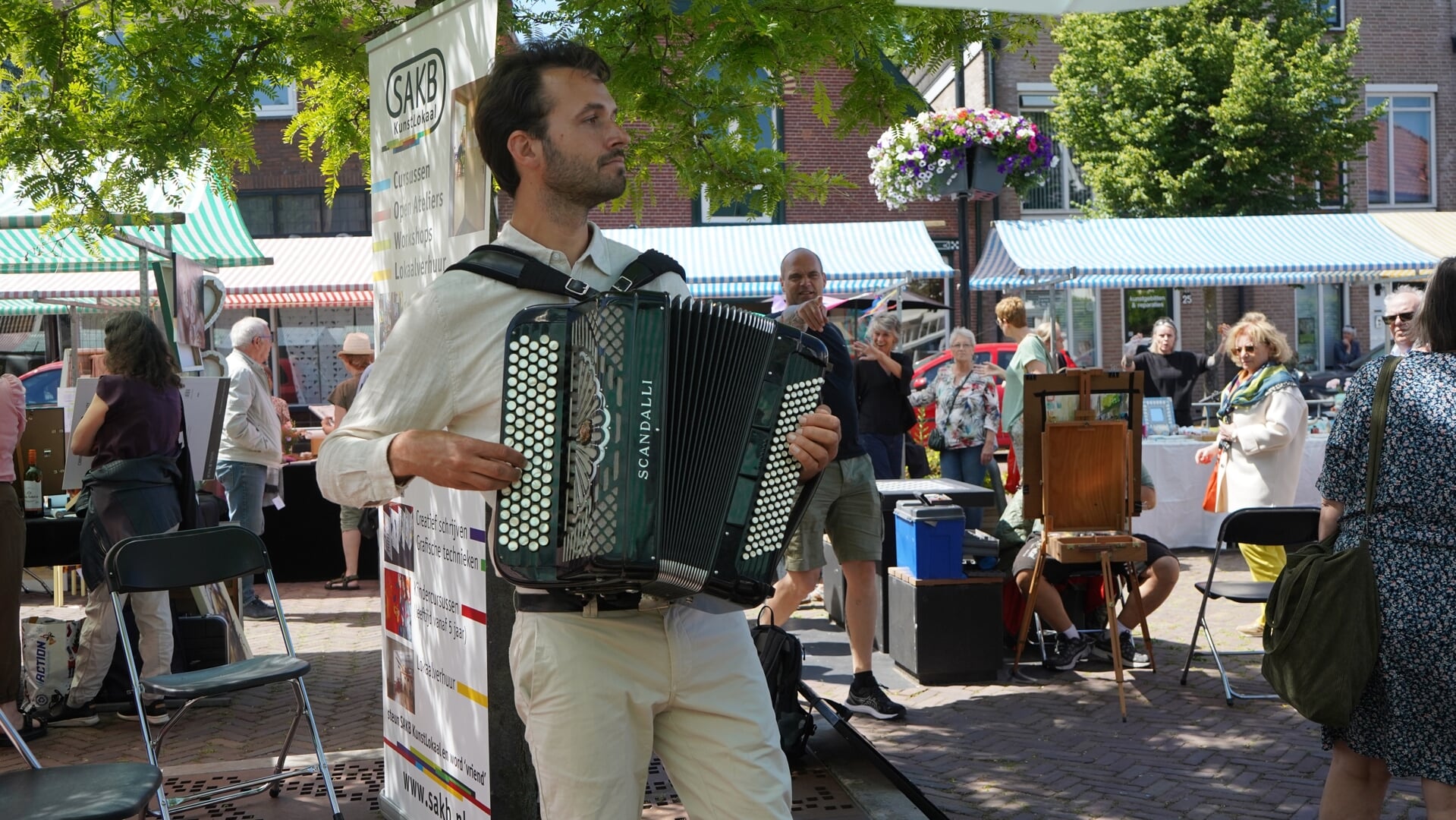 Een accordeonist zorgt op de amateurkunstmarkt voor muziek.