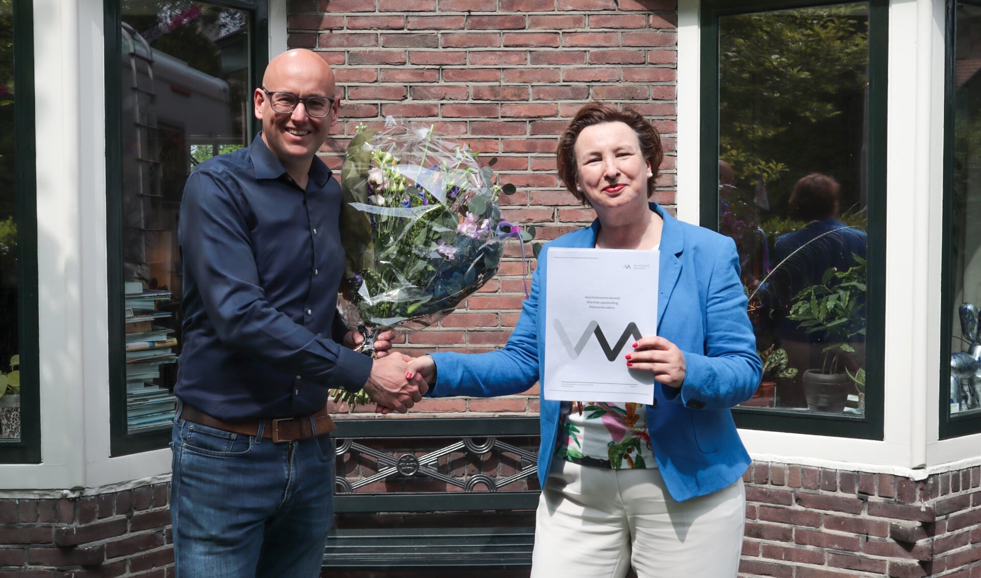 Dhr. Tjoonk uit de Kattekampen ontving als twintigste inschrijver een bosje bloemen van regiodirecteur
Anita van den Berg.