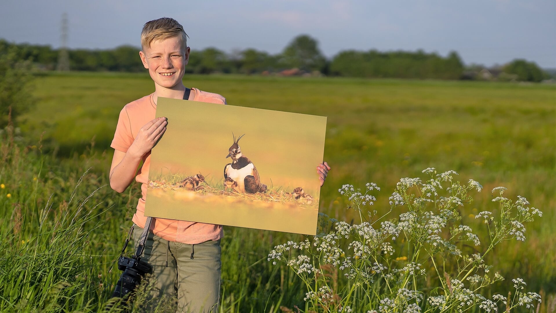 Tussen het hoge gras in de Bennekomse Hooilanden toont David Vink (12) de foto waar hij het meest trots op is.