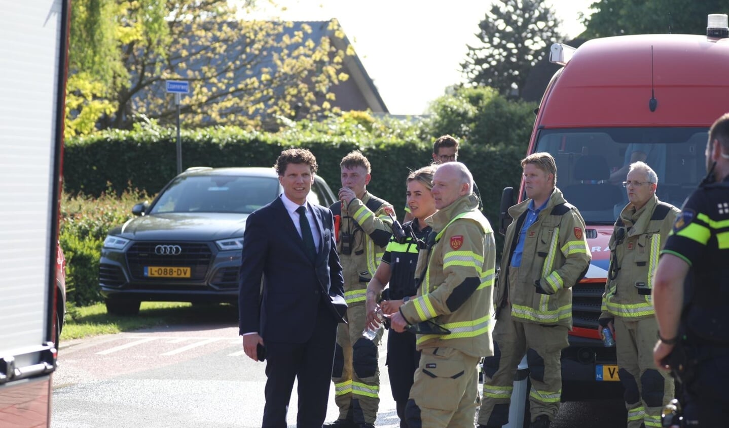 Burgemeester Jacco van der Tak in gesprek met hulpverleners.