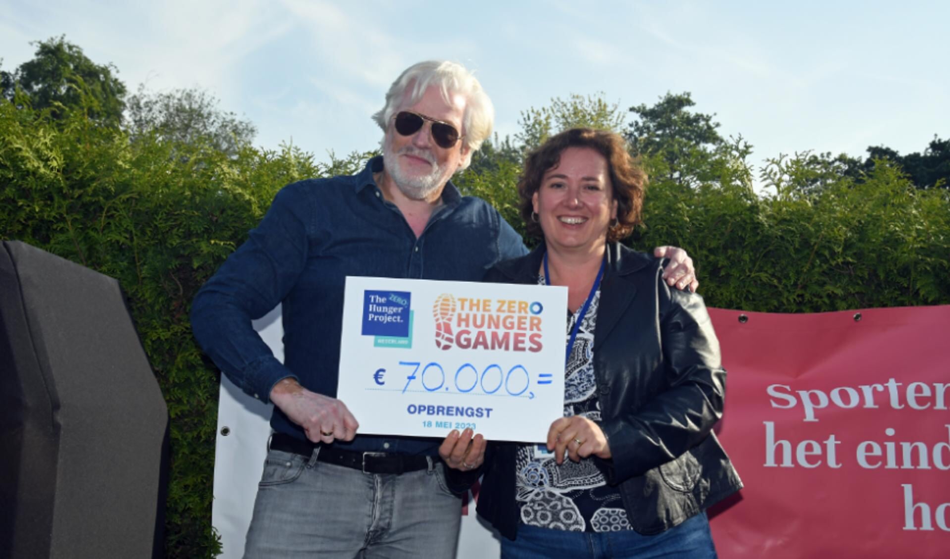 ob van der Laan (Founder & Managing Partner bij NewPort Capital, hoofdsponsor van het toernooi) reikt de cheque uit aan Annelies Kanis (directeur The Hunger Project).