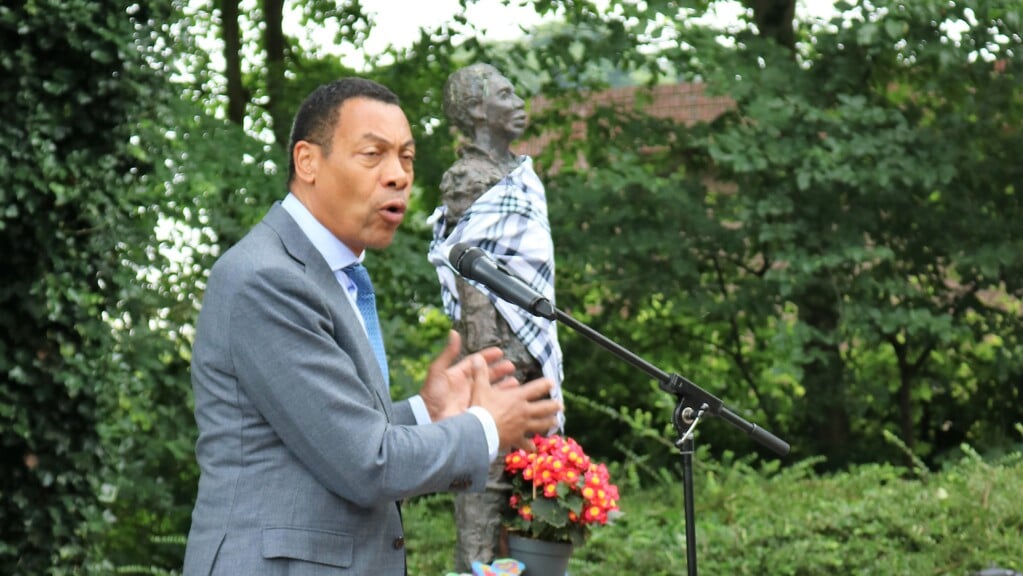 Minister Franc Weerwind sprak de aanwezigen toe, met op de achtergrond het herdenkingsbeeld van Elieser.