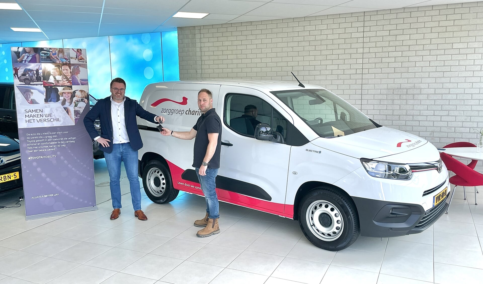 Medewerker technische dienst Melvin van Zorggroep Charim ontvangt van Geert-Jan van Toyota garage Gent de sleutel van de nieuwe elektrische Toyota.