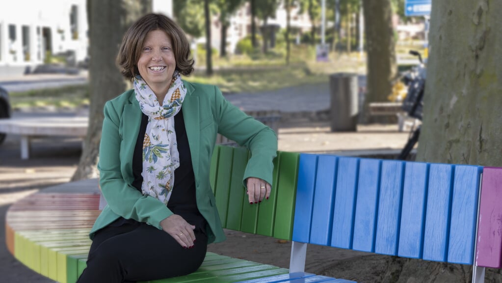Wethouder Karin Bijl op de regenboogbank in de gemeente Ede.