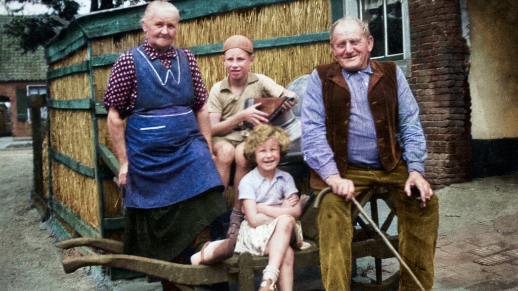 Heintje en Kees, de grootouders van de auteur, met buurkinderen bij het drooghok voor de melkbussen. Deze ingekleurde foto siert de omslag van het boek