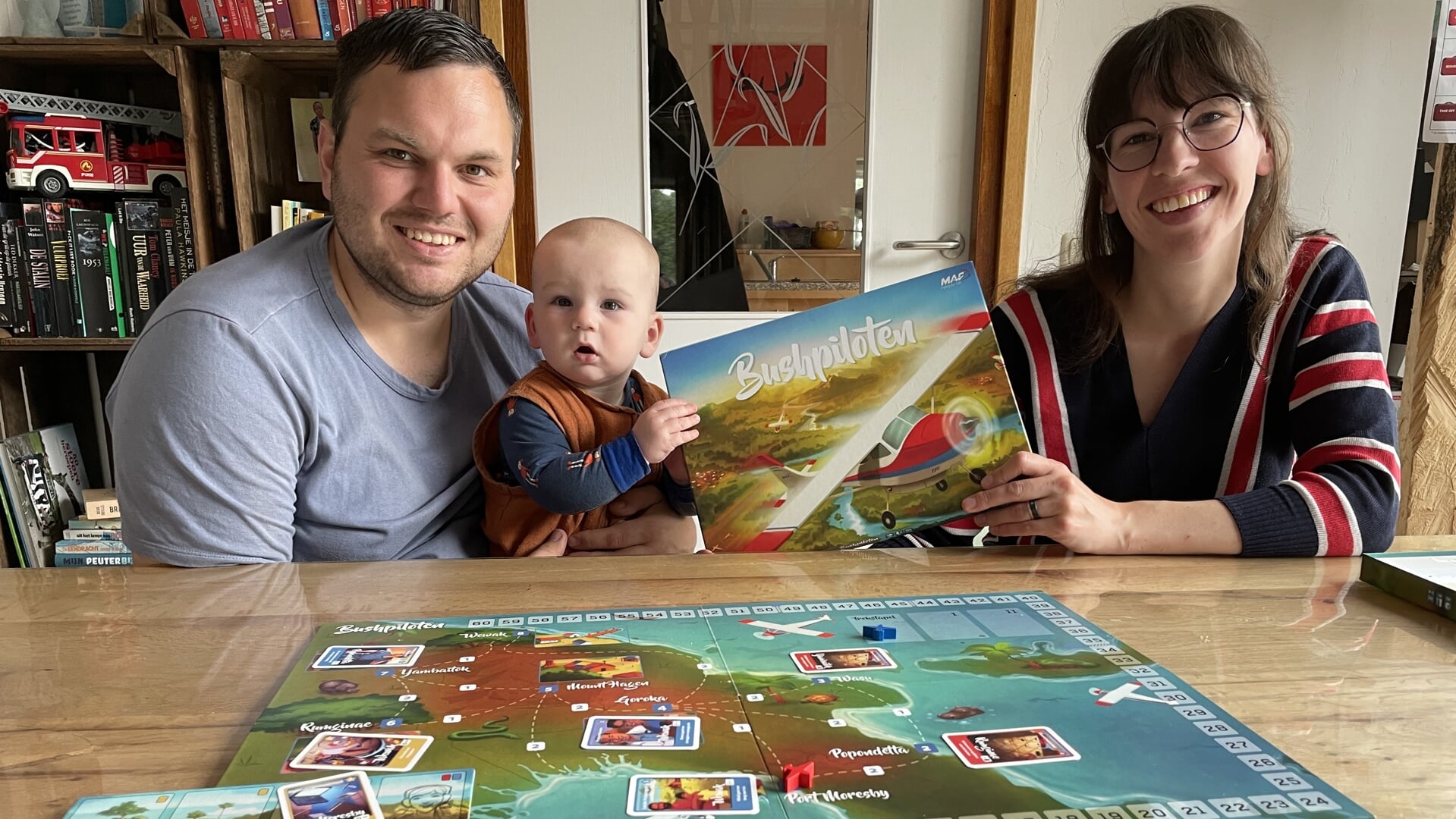 Joost en Anke met hun zoontje Joshua met het door hen zelf bedachte MAF-bordspel 'Bushpiloten'.