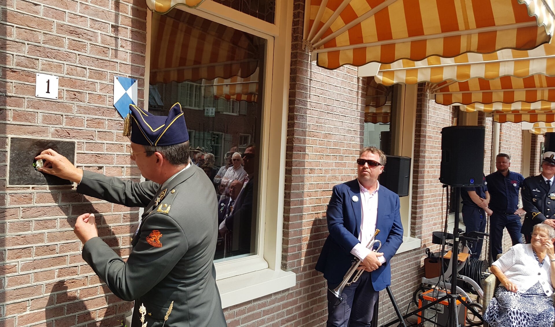 Generaal Paul Hoefsloot plaatst de eerste anjer bij Hotel De Wereld.