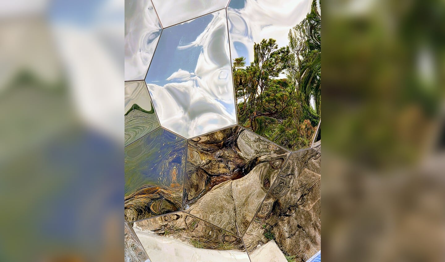 Zweedse zomer: water, bomen, rots en blauwe lucht weerspiegeld in het 'solar egg', een kunstwerk op een eiland bij Stockholm.