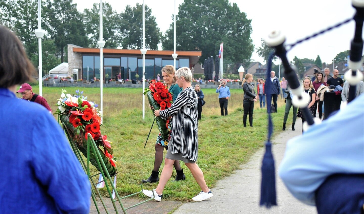 Foto: Janet Bakker (voorgrond) en Pauline Kuijt leggen namens Renkum Leeft een krans bij het monument op de Renkumse heide.