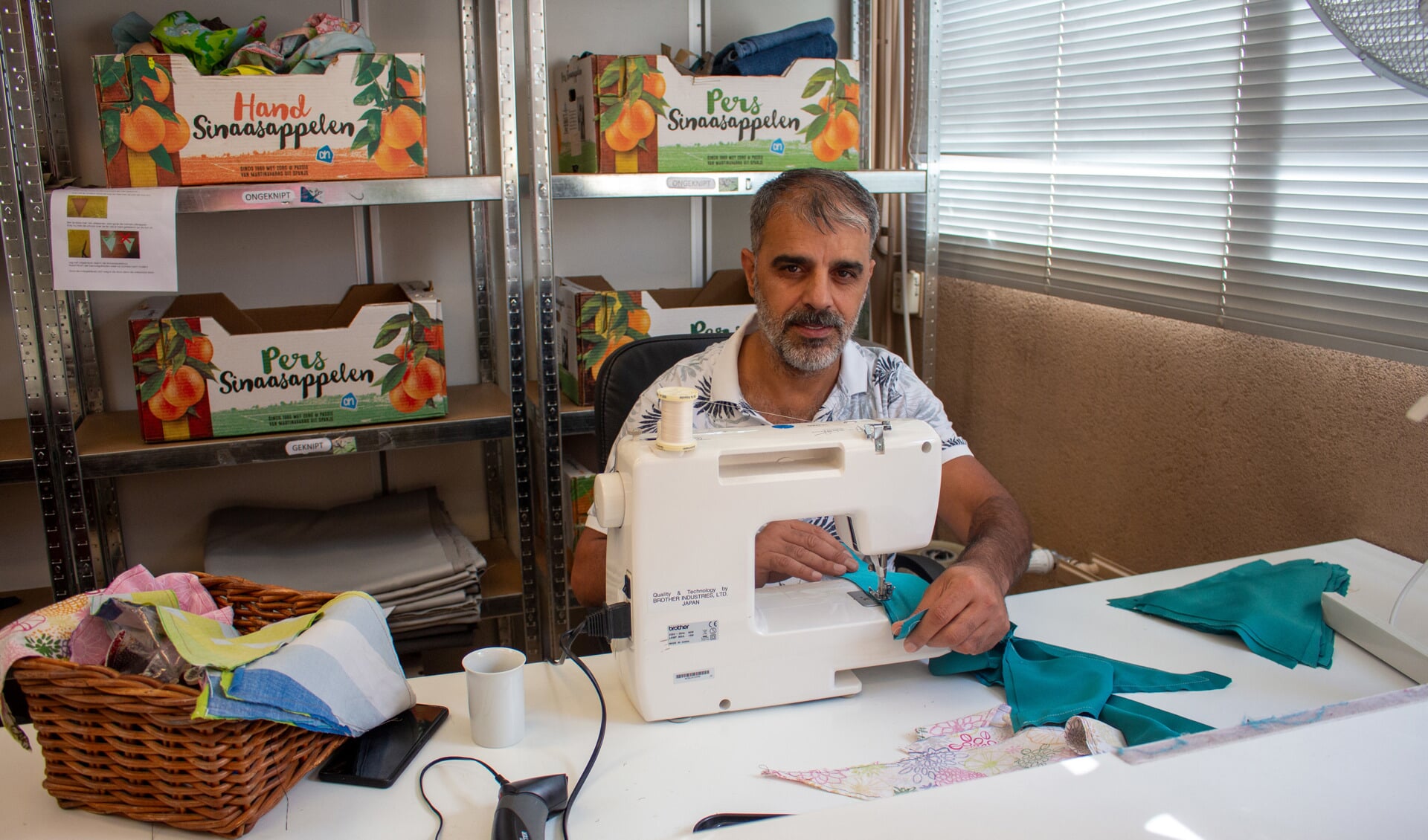 Mohamed Esleem maakt vlaggenlijnen bij de Kringloop. Op de Vrijwilligersmarkt kun je onder andere daarin een workshop doen.