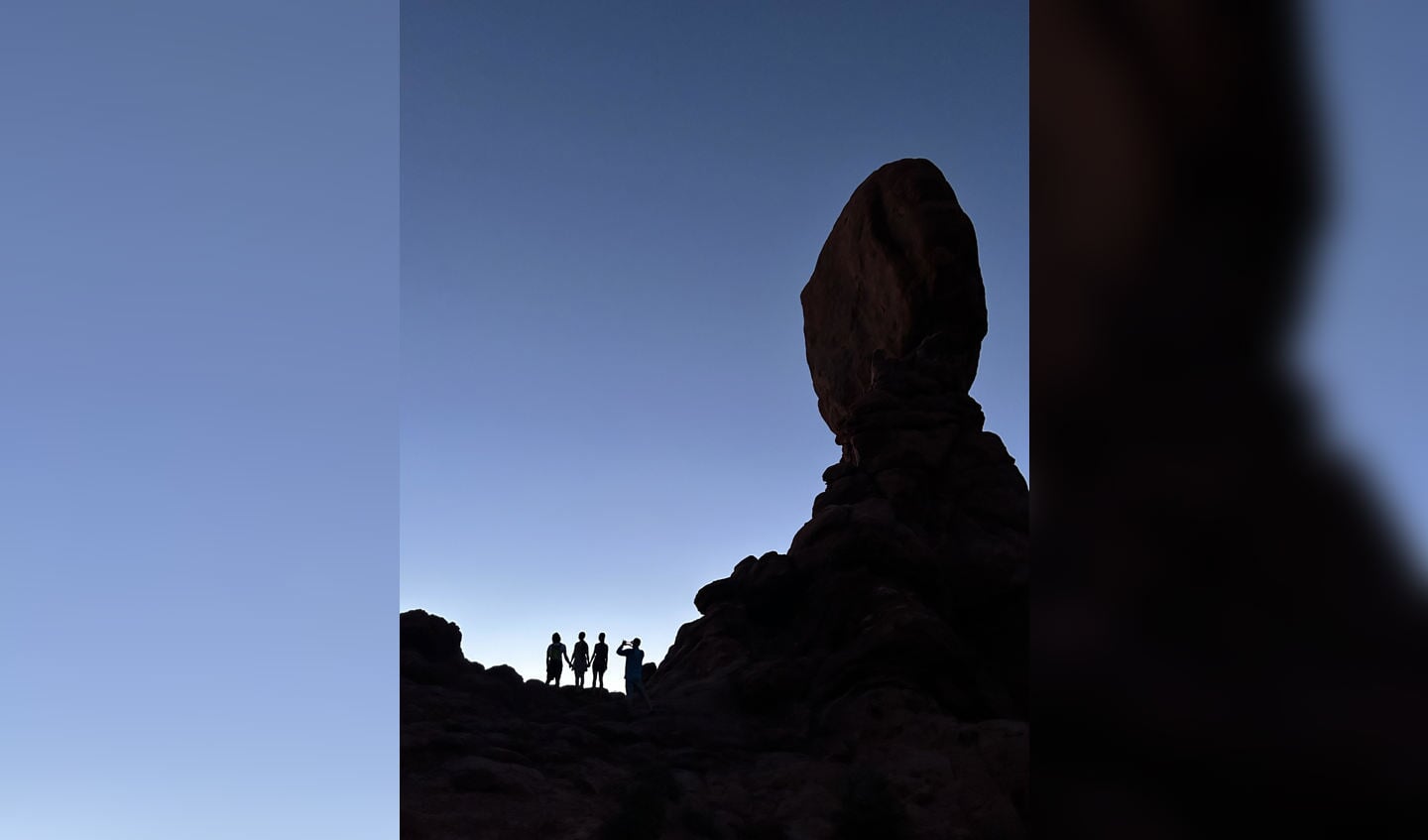 Groepje toeristen die foto maakt met smartphone bij Balancing Rock in Arches National Park - Moab, Utah USA