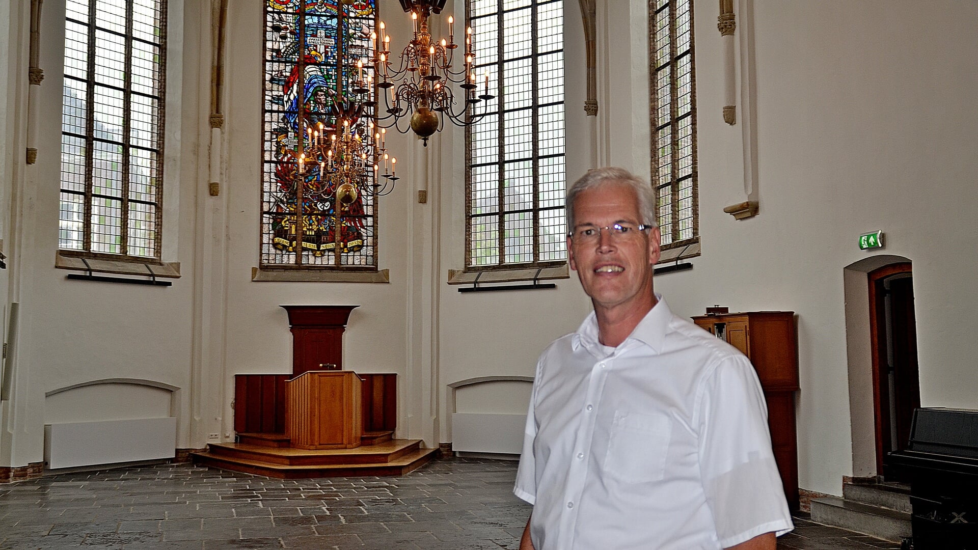De nieuwe dominee Willem Jan Dekker (wijkgemeente Johannes) voor het Bevrijdingsraam in de Grote Kerk op de Markt