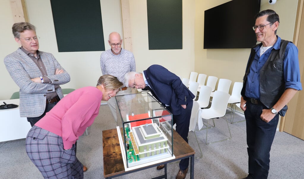 Burgemeester Petra Doornenbal van Renswoude bekijkt het miniatuur-gemeentehuis van Ton Nennie (rechts).  