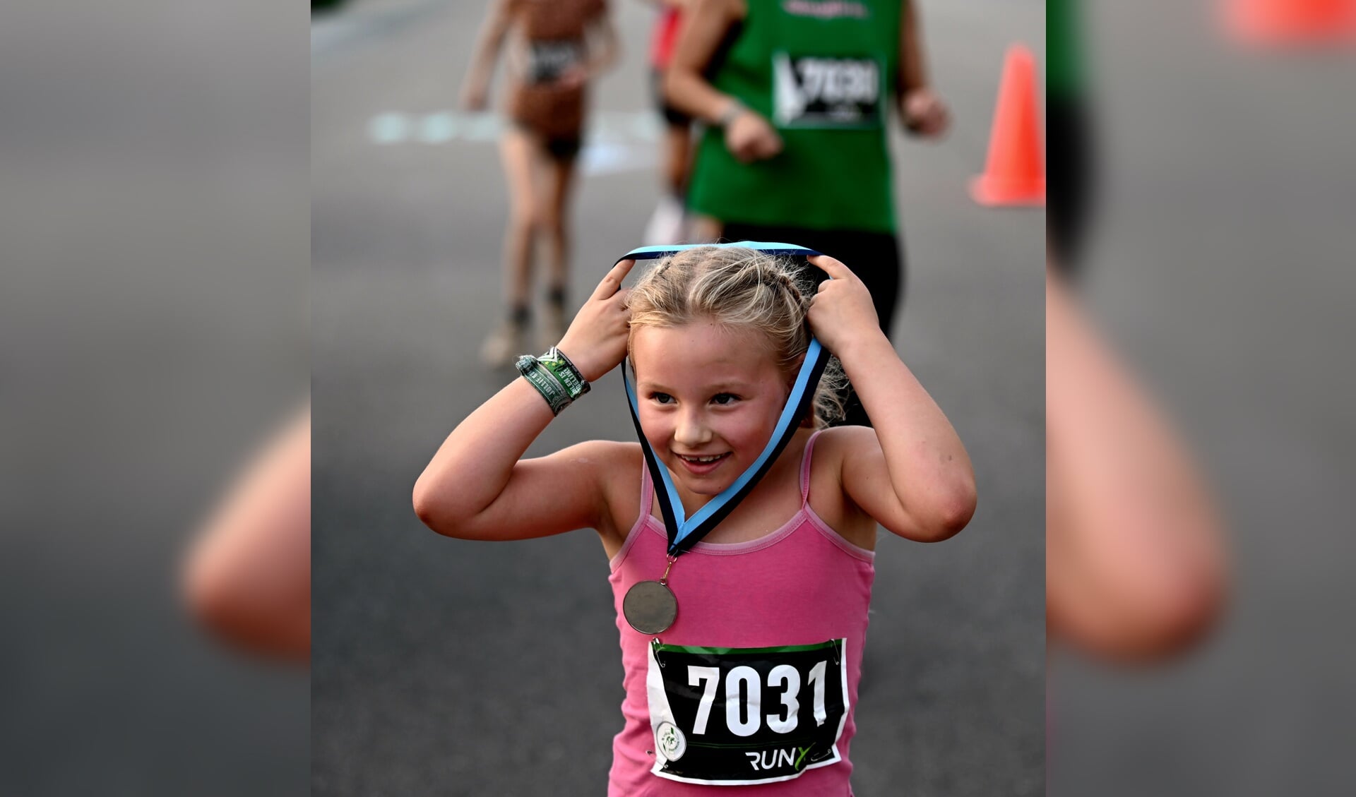 Eén van de jongere deelnemers Eva Meijer neemt trots de medaille op de 2,5 km in ontvangst.