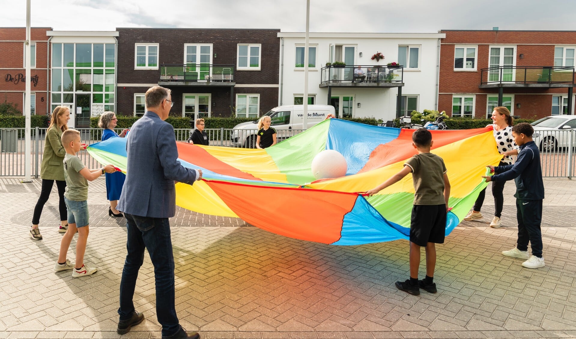 Wethouder Jolanda de Heer, bestuurders van het speciaal onderwijs in Barneveld en schoolkinderen houden samen de 'kansenbal' omhoog.