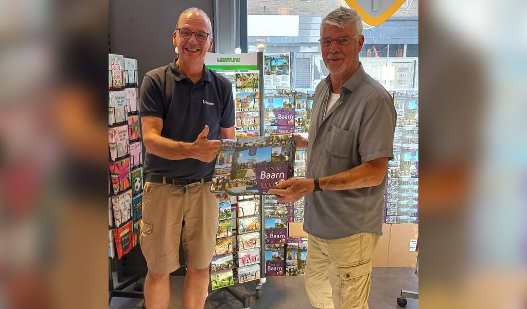 Bruna-eigenaar Robert Batenburg (l) overhandigt de Baarnpuzzel aan de aller eerste klant, de heer Brattinga. 