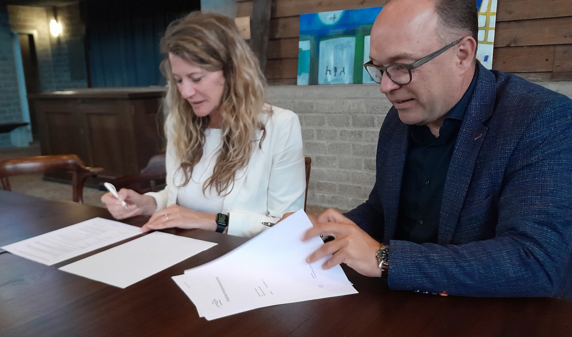 Wethouder Daniëlle van Bentum en Arthur van Iterson van Woonvlinder ondertekenen de HOK.
