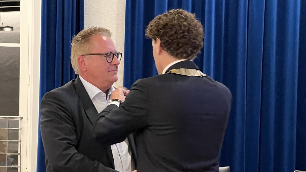 Jan Willem van den Born krijgt een gouden speld van de gemeente Barneveld opgespeld door burgemeester Jacco van der Tak.