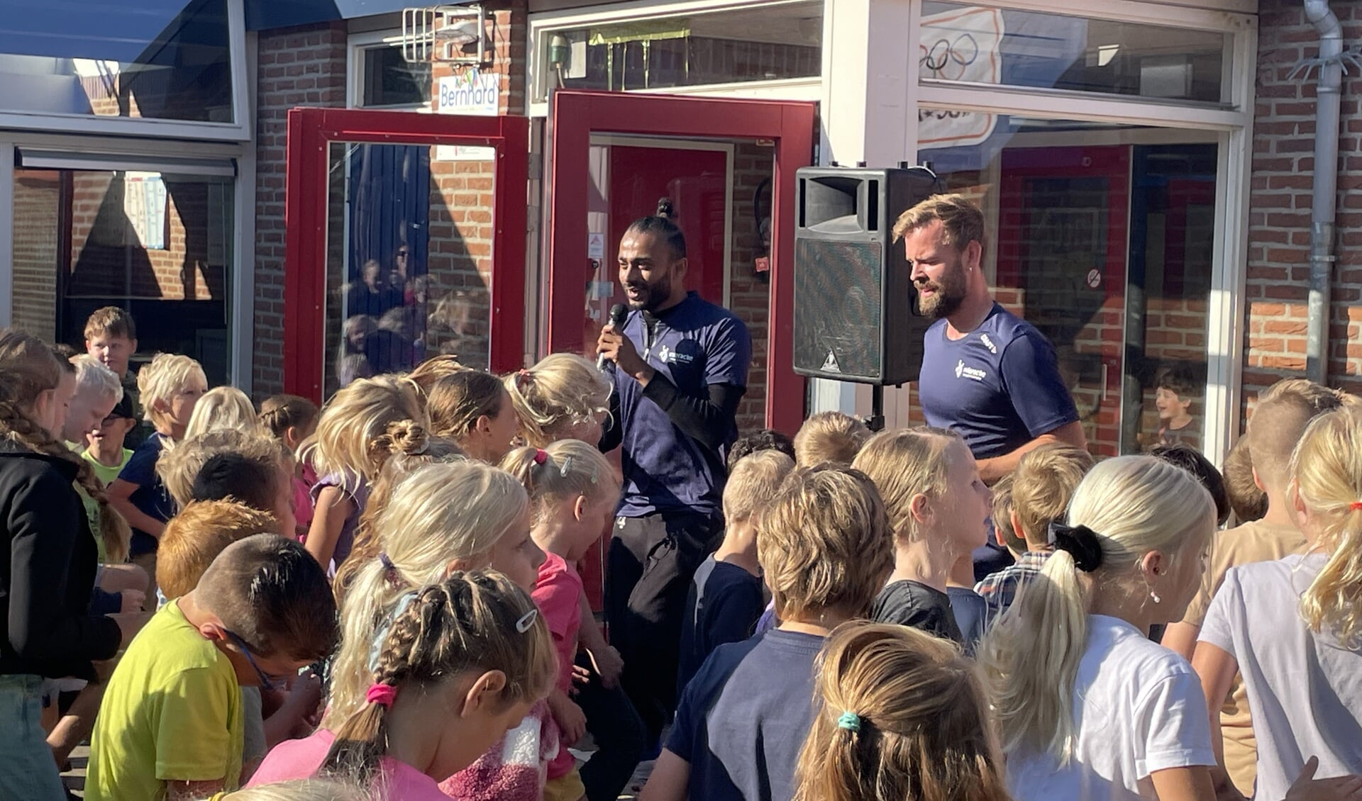 Wethouder Sarath Hamstra en vakleerkracht bewegingsonderwijs Jan Bosch sporten met de kinderen van de Bernhardschool.
