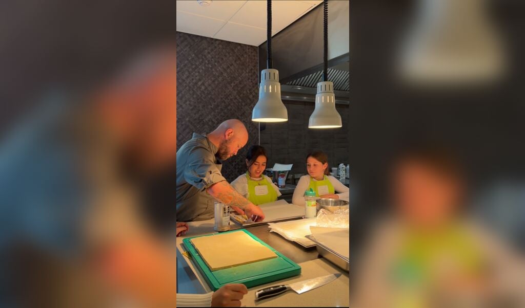 Chef kok Daniël van der Wal en helpt de kinderen bij het bereiden van hun eigen 4 gangen-diner