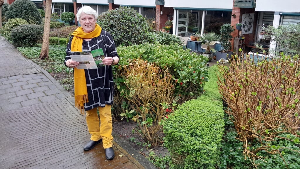 Gerrie Overweel poseert met haar 'wandelfolder' in de binnentuin aan de Vlinthof.