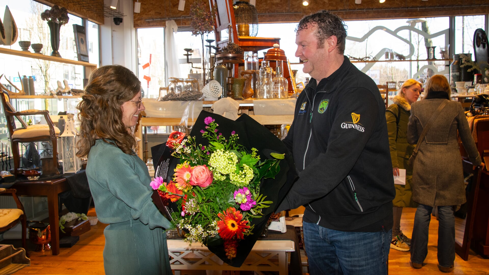 Anne-Marie Heiwegen van 't Spoorhuis neemt een boeket bloemen en de prijs voor de etalagewedstrijd in ontvangst.