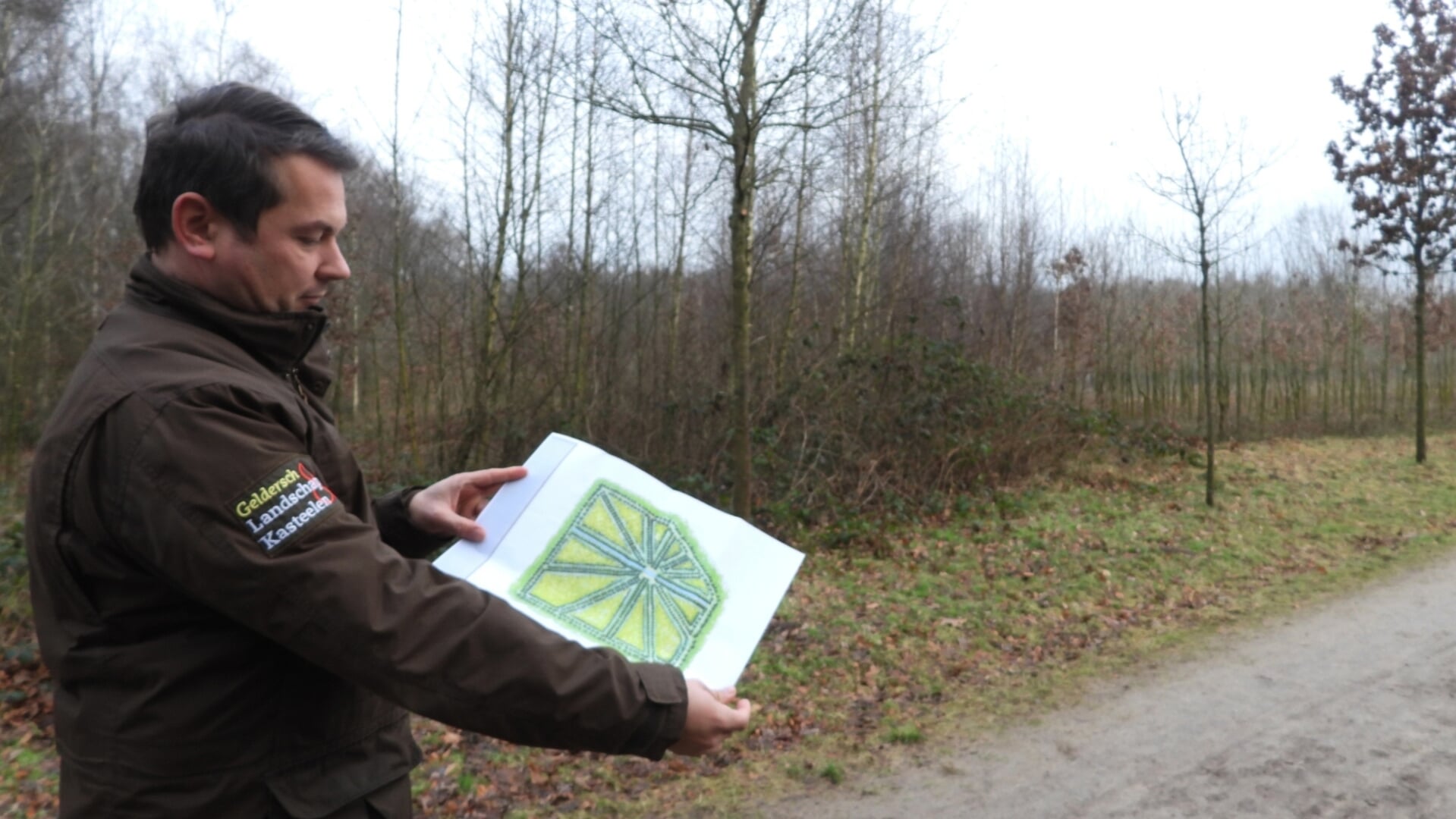 Boswachter Roy Mes toont een plattegrond van het Veertienlanenpunt op Landgoed Schaffelaar.