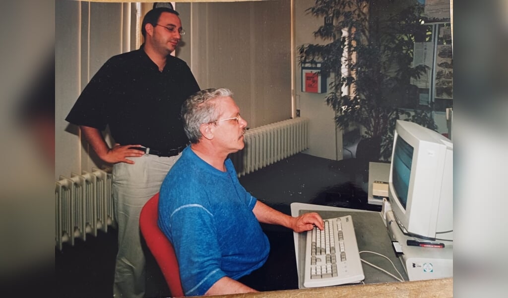 Marc Looijen (links) met chef-redacteur Wim Mulder in de redactieruimte aan de Hoogstraat, samen kijkend naar de sportpagina.