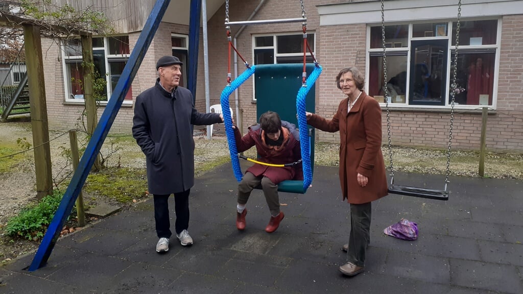 Laila neemt plaats in de schommel, links haar vader Mar Dekker en rechts teamleider Margreet van Ommeren.