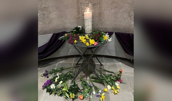 Bloemen leggen onder 't kruis in de Oude Kerk