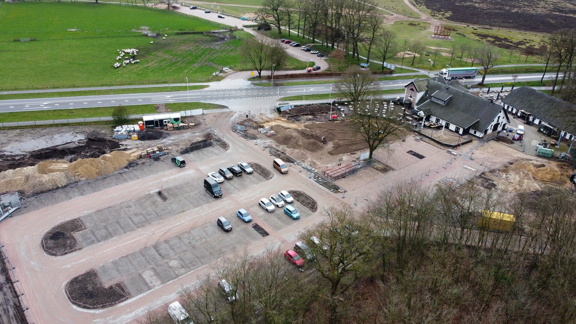 De nieuwe parkeerplaats (onder) vervangt de huidige parkeerplaats naast de schaapskooi (boven).