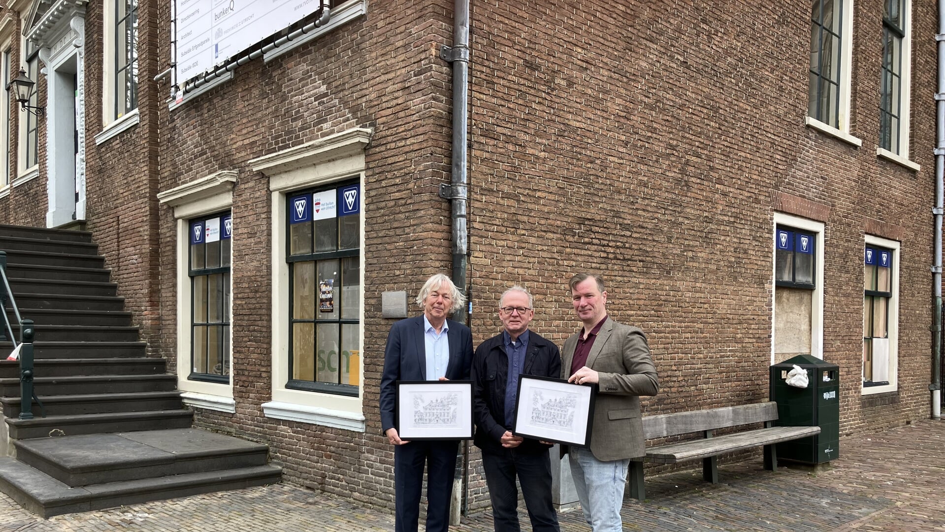 Roger Caubo (VVV) overhandigt de ingelijste tekening aan de wethouders Jan Kuiper en Jeroen Brouwer
