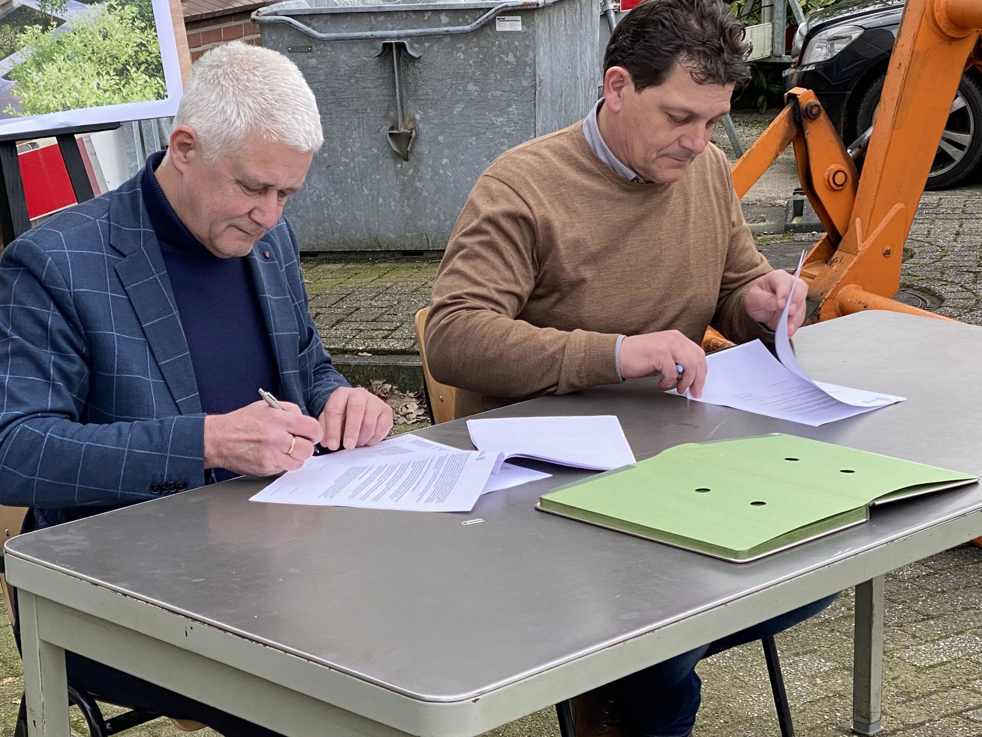 Wethouder Henk van der Schoor en Henk ten Broek van Bouwbedrijf Osnabrugge zetten hun handtekening onder de aannemingsovereenkomst.