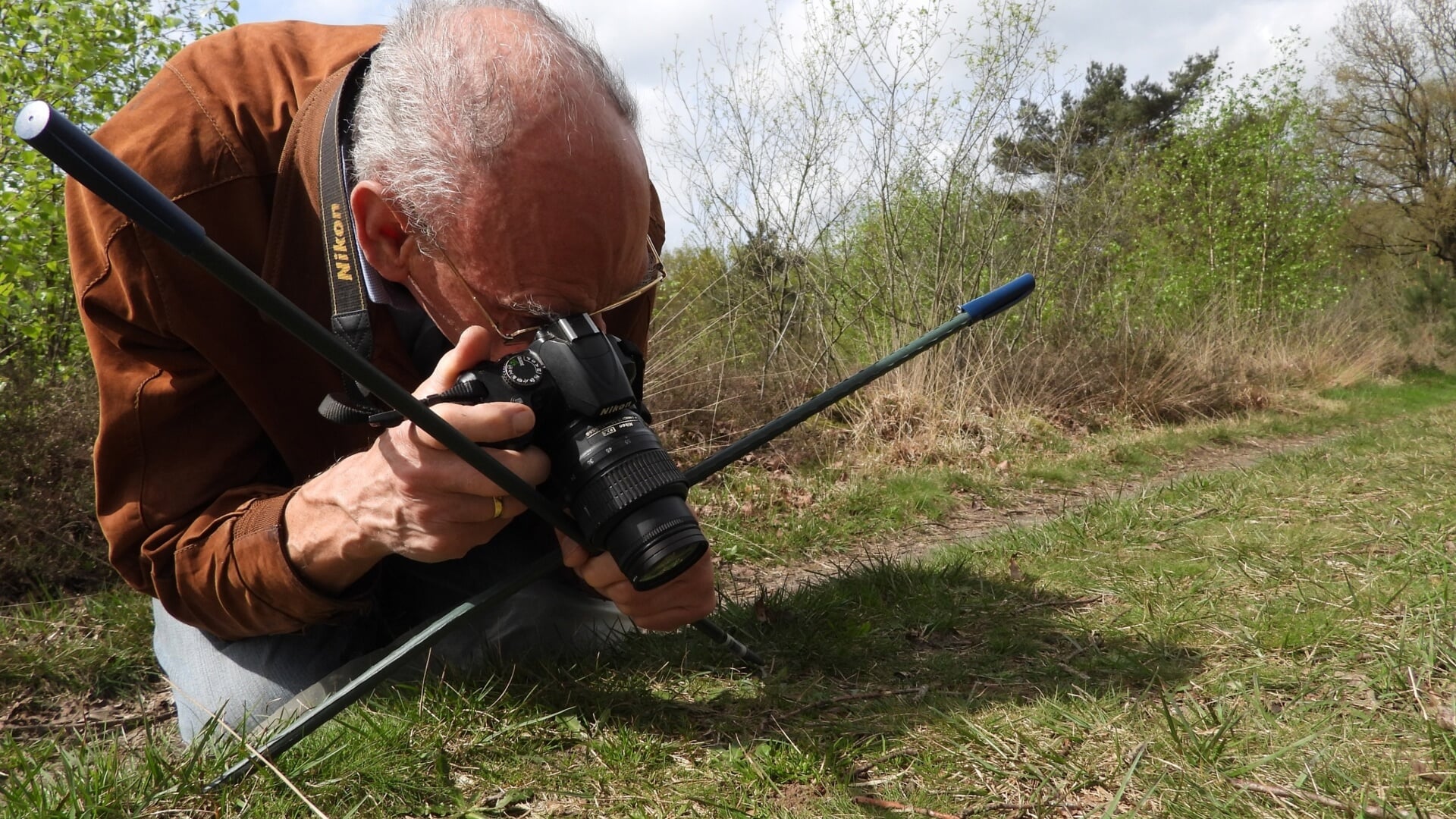 Natuuronderzoeker Aart Malestein fotografeert graafbijen met behulp van zijn ‘statief’.