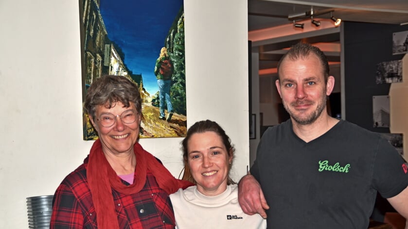 Nicole Pluim (links) samen met Brigitte en Remco van Dijk voor één van Nicoles aquarellen in café De Tijd, 