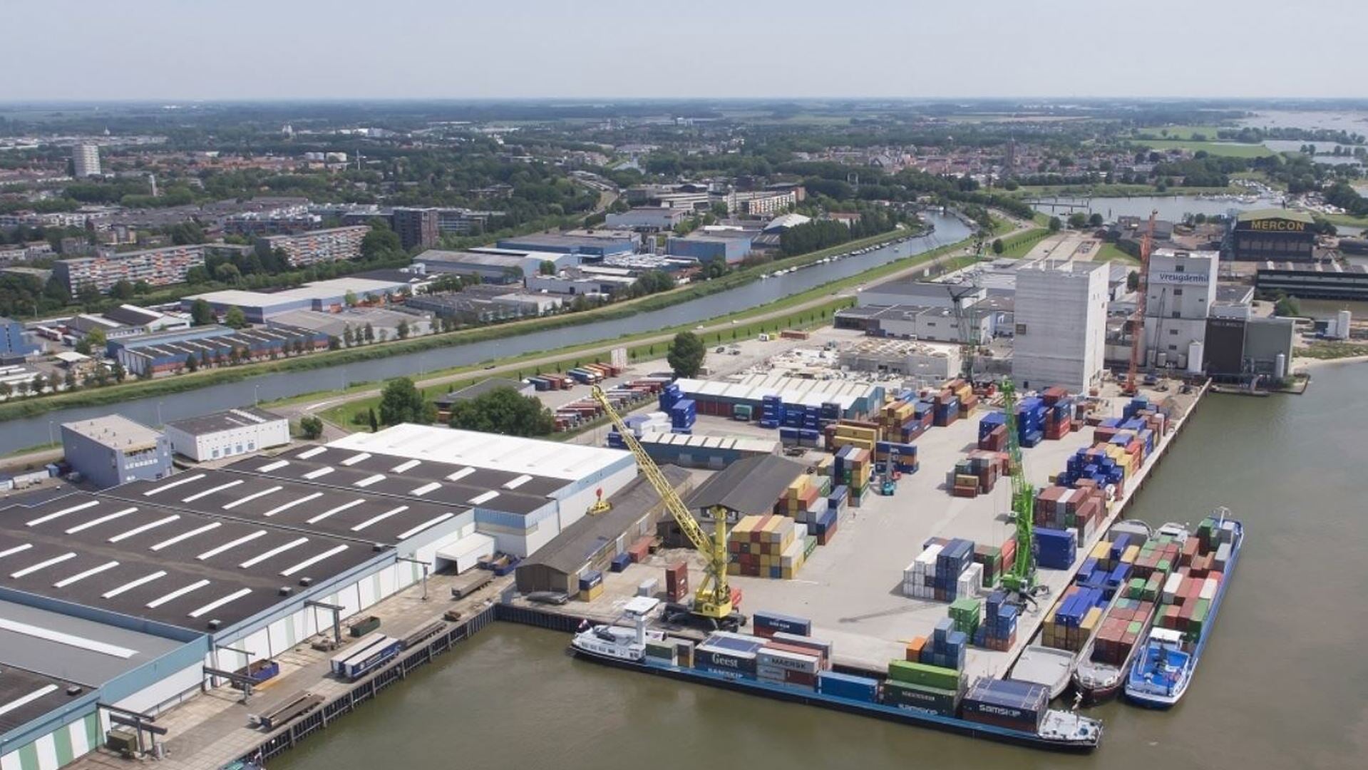 Bedrijventerrein langs de rivier en op de achtergrond de Schelluinse kade