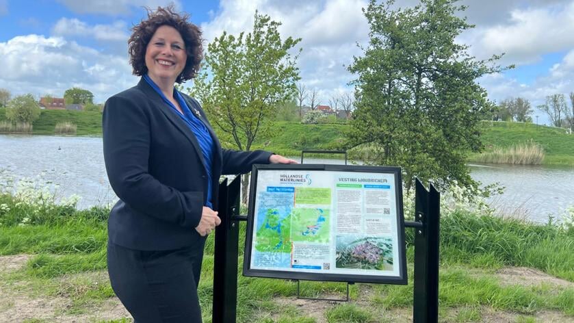 Wethouder Claudia Schipper bij het nieuwe bord nabij vesting Woudrichem