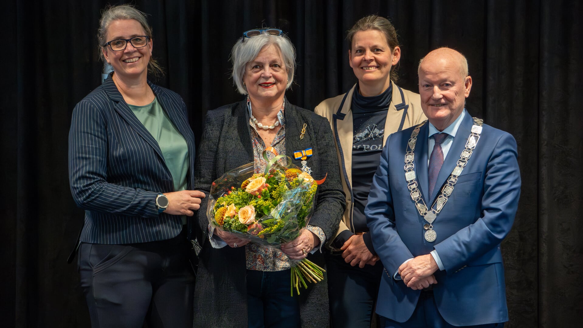 Op de foto Marianne Offereins geflankeerd door haar dochters Aline en Annemarie en burgemeester Ruud van Bennekom.