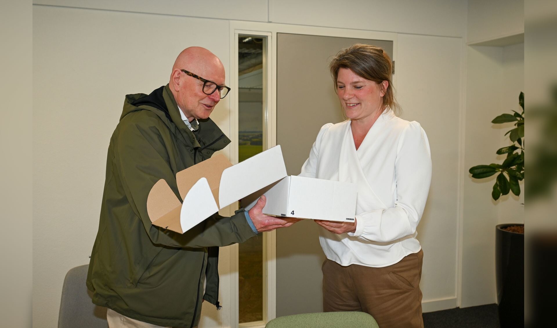 Ton Hilhorst overhandigt de doos met bezwaarschriften aan wethouder Aukje Treep.