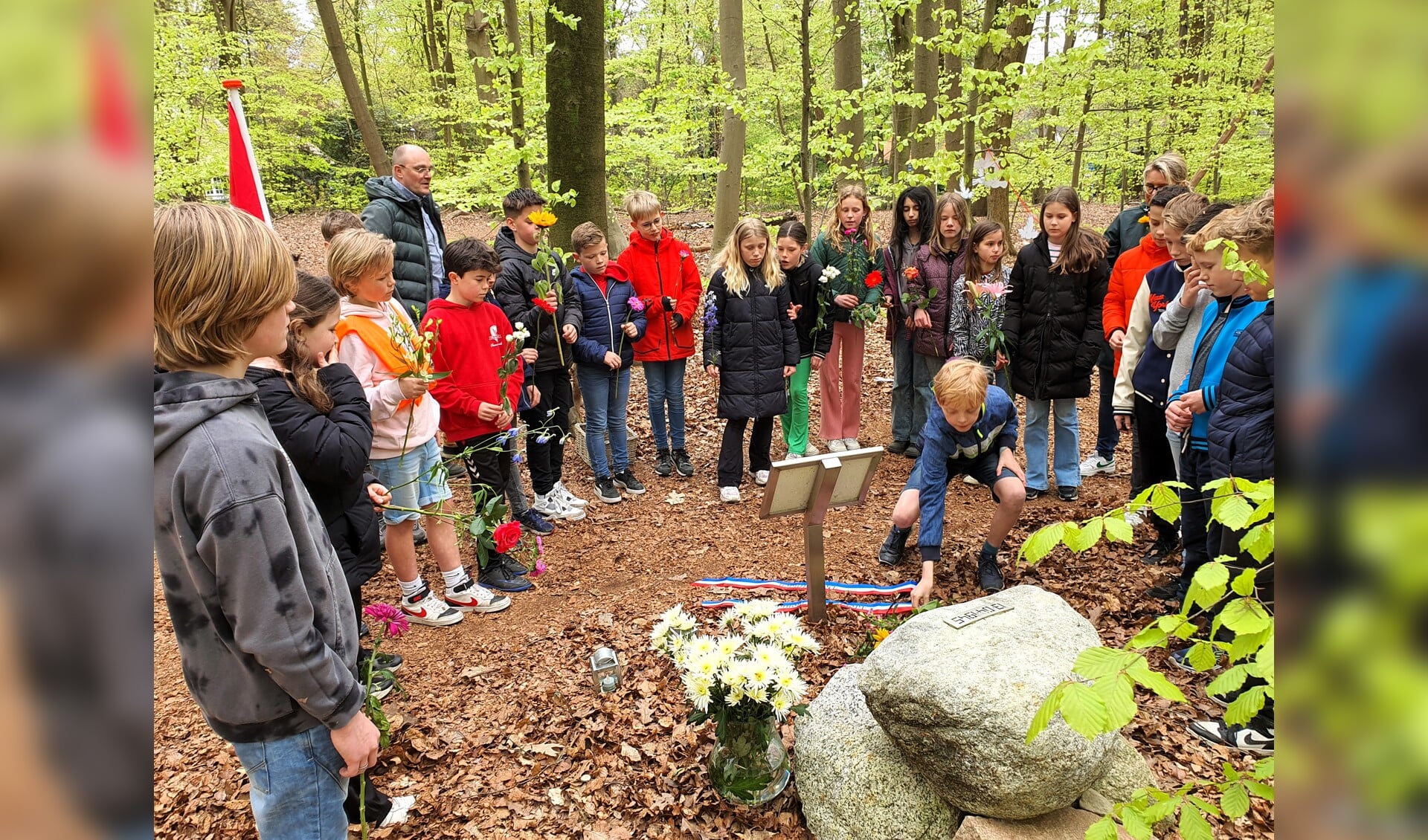 Leerlingen van groep 7 van De Plataan leggen bloemen bij het monument ter nagedachtenis aan de gebroeders van Steenbergen.