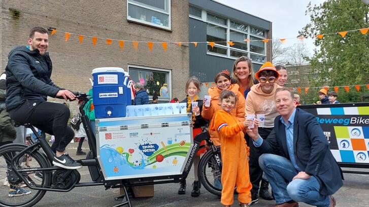 Wethouder Onderwijs Frank Berkhout deelt water uit aan kinderen op het schoolplein van
Basisschool De Horizon tijdens de Koningsspelen.