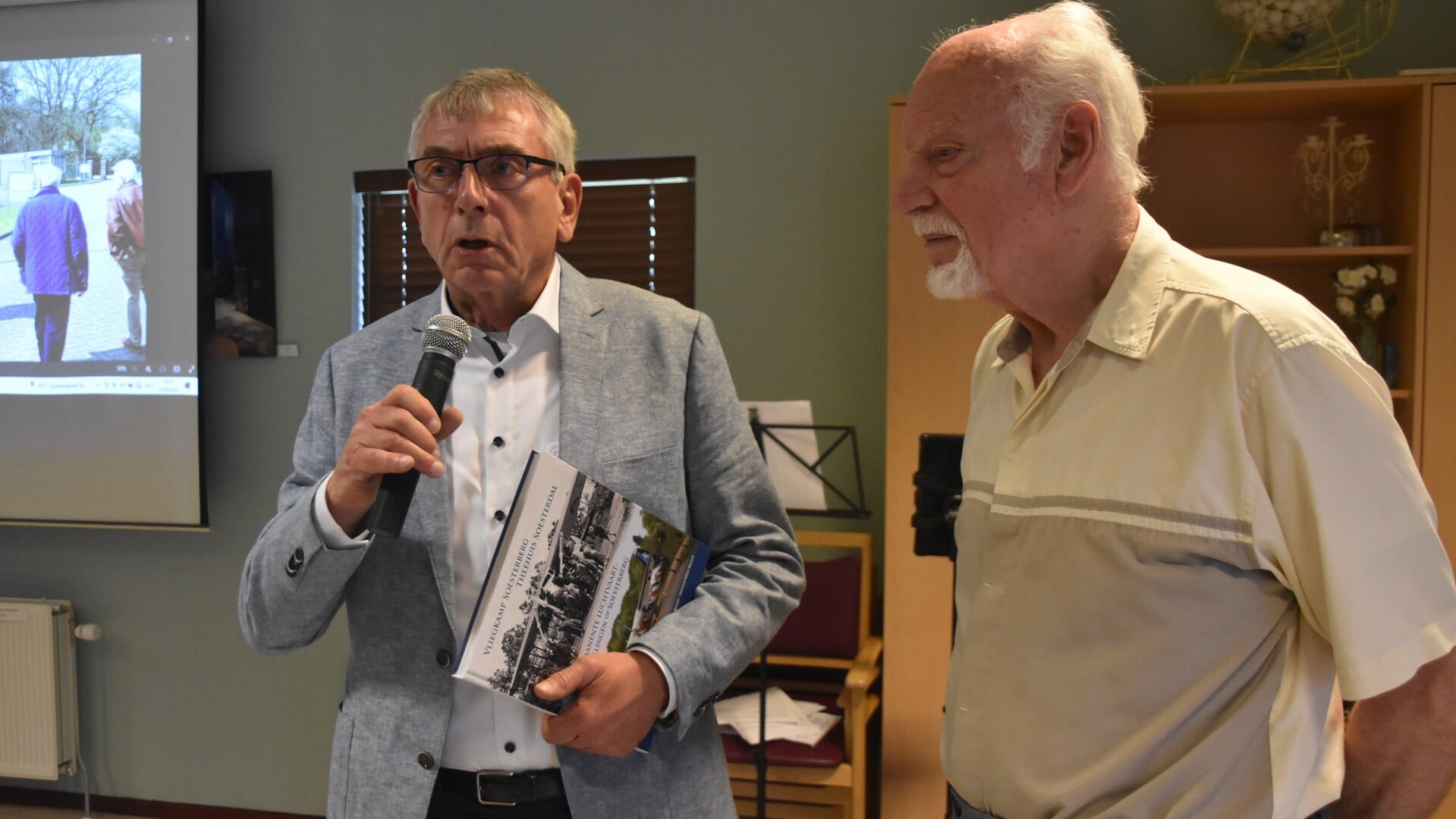 Erik Couturier (links), nakomeling van de exploitanten van Theehuis Soesterdal (1925-1940), neemt het eerste boek van Dik Top in ontvangst.