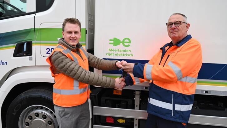 Scania Account manager Niels Verheij (L) overhandigt de sleutels van de nieuwe Scania BEV aan chauffeur Arie van Giesbergen.