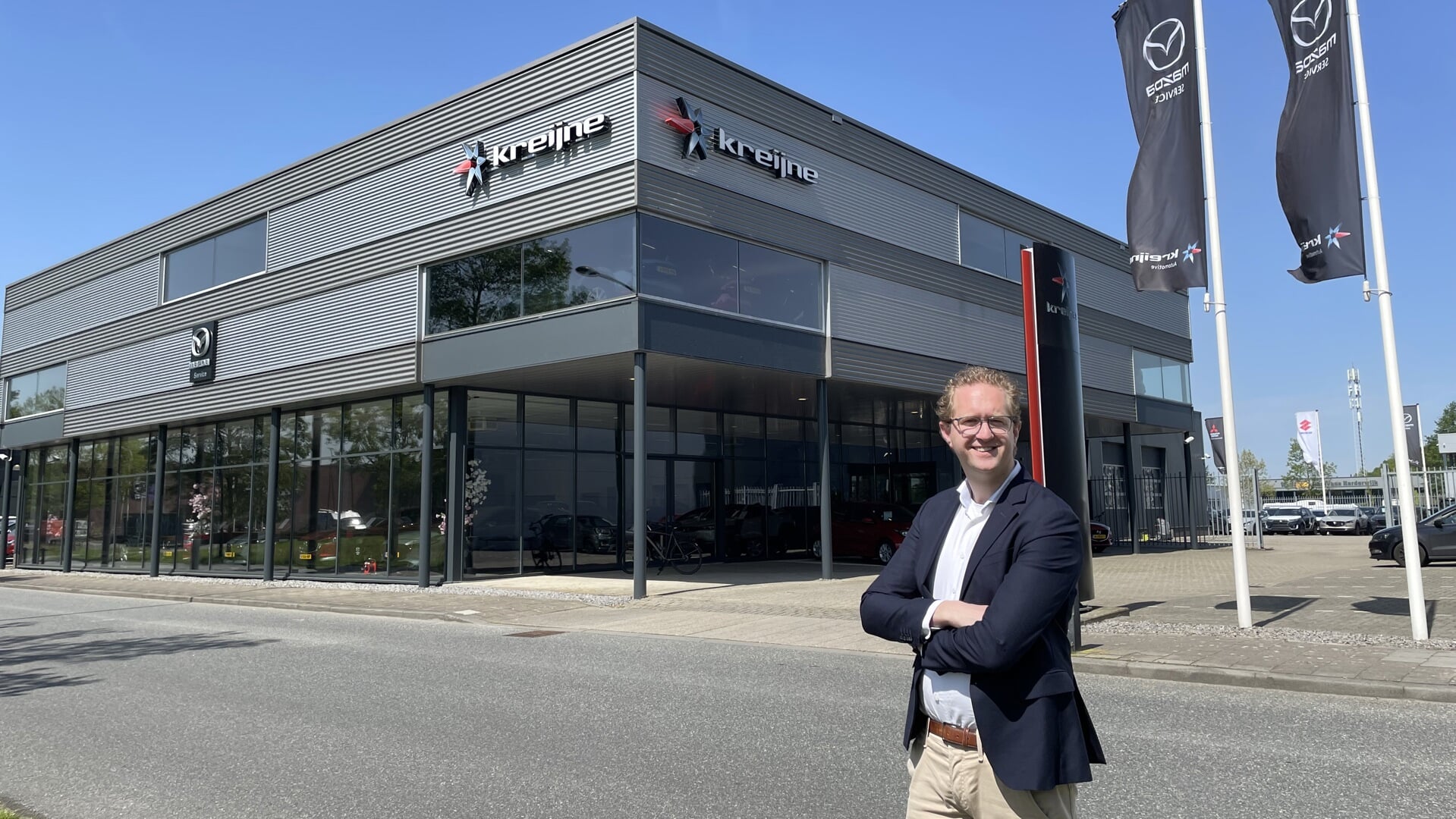 Jasper Bijl staat vol trots voor de nieuwe Mazda-vestiging van autobedrijf Kreijne aan de Zuiderbreedte 8.