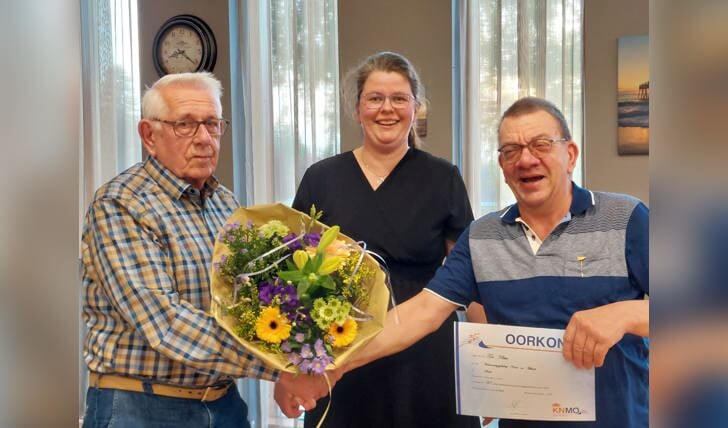 Ton Klein rechts op de foto wordt gefeliciteerd door bestuurslid Jan Bouwman en de secretaresse Lianne Verstegen