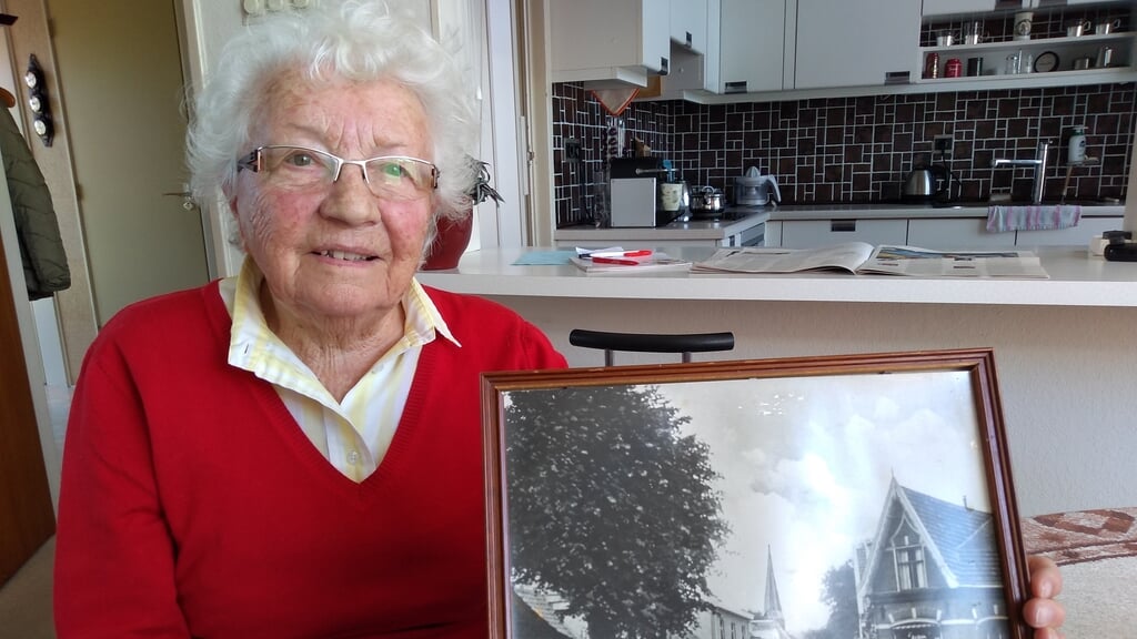 Eefje Vastenburg met de foto van het huis in Putten waarin ze opgroeide.