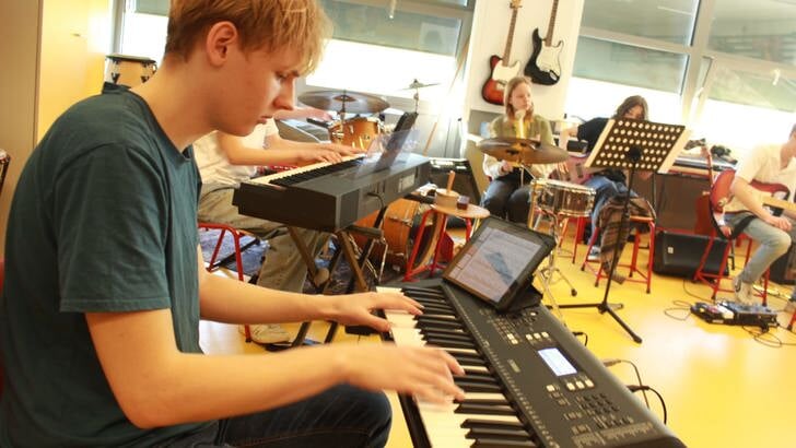 Repetities van de jongeren verantwoordelijk voor de muzikale ondersteuning van het schooltoneel.