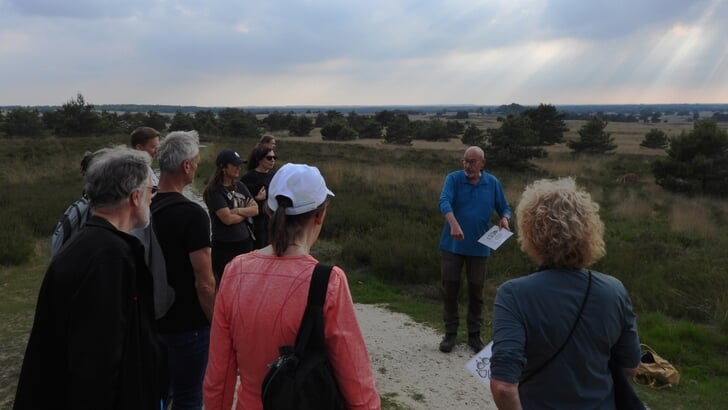 Staatsbosbeheer-vrijwilliger Ronald Wessels legt excursiedeelnemers bij Hoog Buurlo uit hoe een wolf loopt.