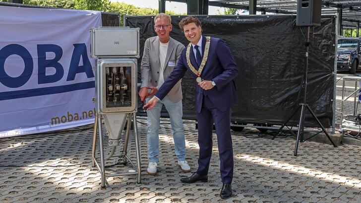 Burgemeester Jacco van der Tak en Willem van der Wiel openen het zonnedak.