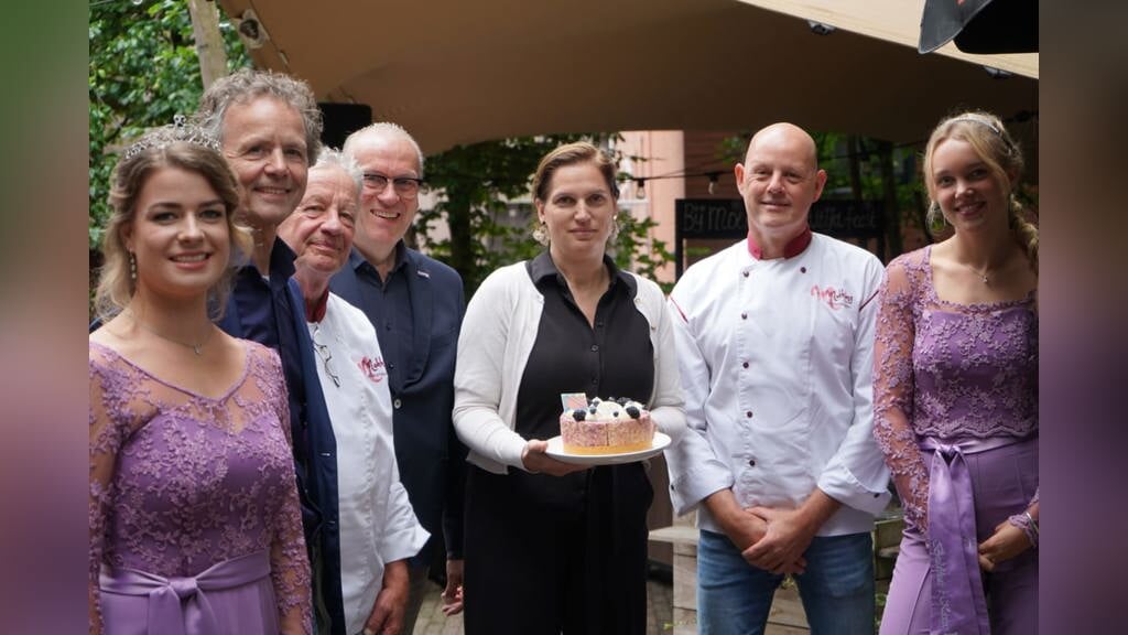 Annette Hoogwerf (midden) toont de gepresenteerde taart.